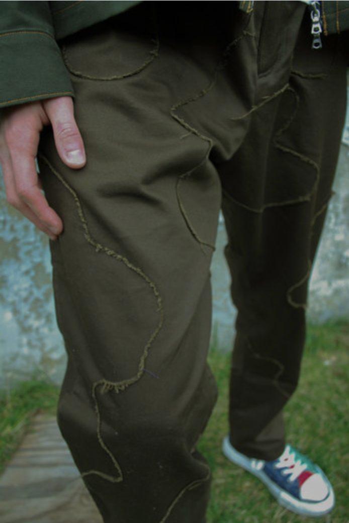 Fabric study — hand-stitched appliqué on olive trouser