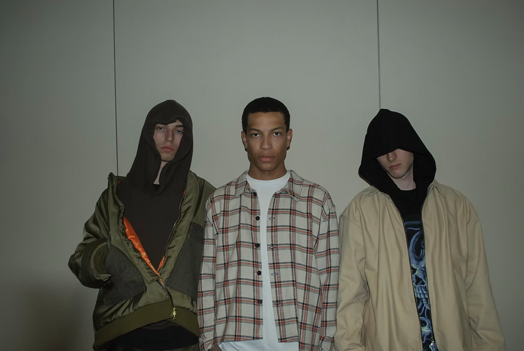 Three models in hoods and plaid, group portrait